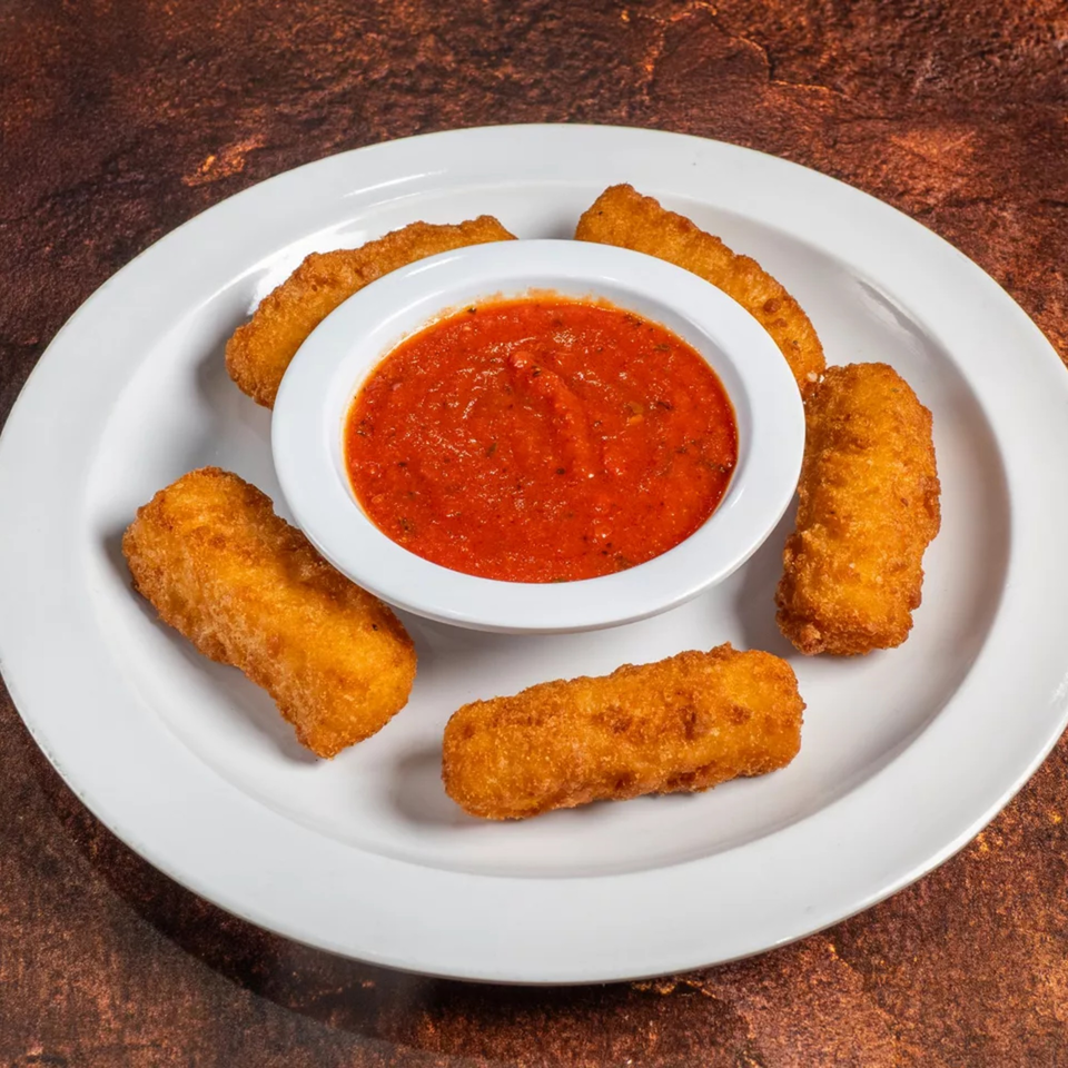 Five golden-brown mozzarella sticks arranged around a white bowl of red marinara sauce on a white plate.